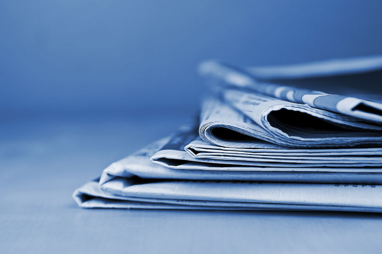 Stack of newspapers lying on the table blue toned