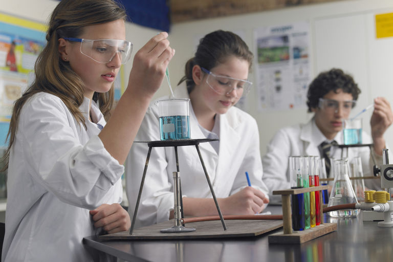 Teenage students caring out experiments in chemistry class