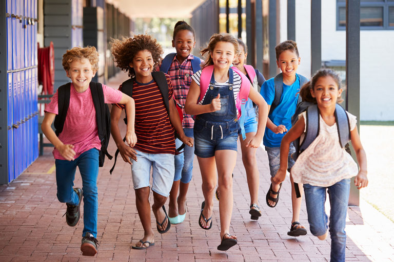 School kids running in elementary school hallway