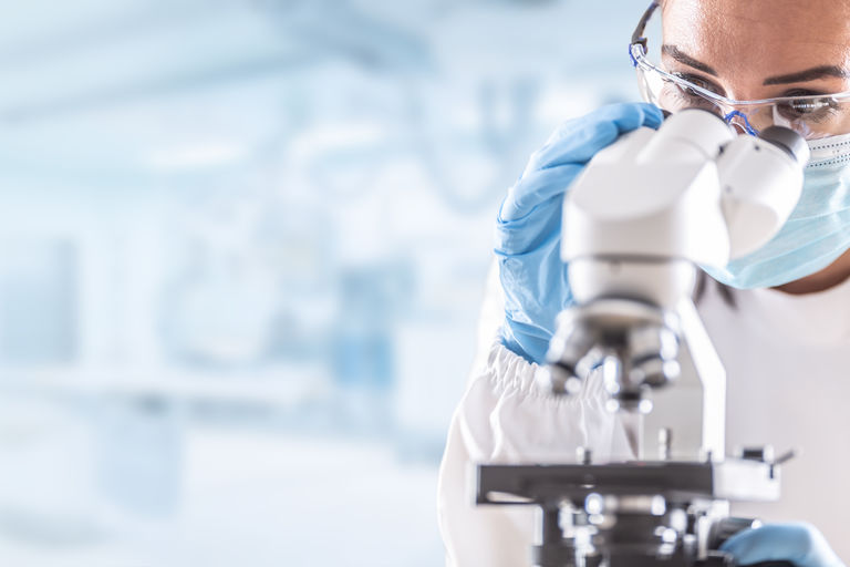 Female lab technician in protective glasses