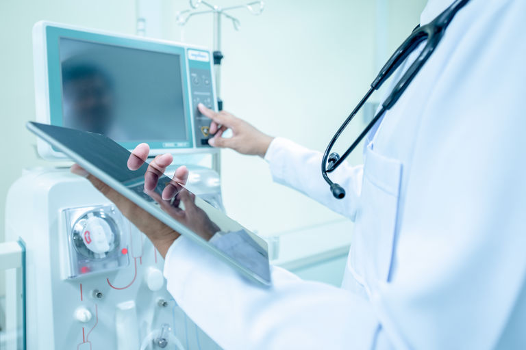 Doctor and advanced dialysis equipment in hospital background for commercial business