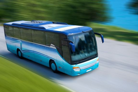 A blue bus driving in a country road A blue bus driving in a country road