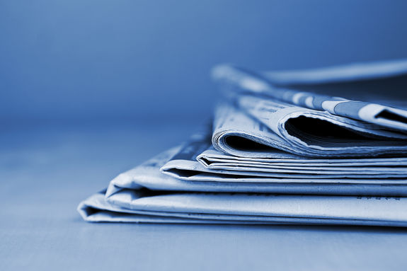 Stack of newspapers lying on the table blue toned